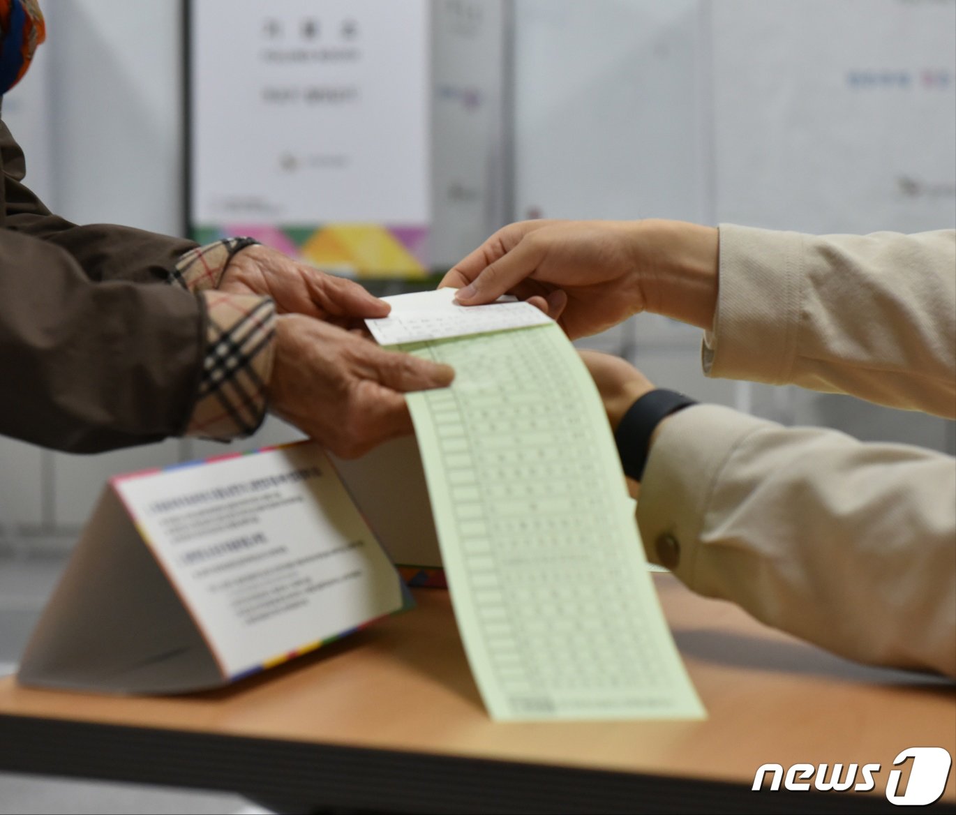 본문 이미지 - 제22대 국회의원 선거 본투표 당일인 10일 오전 전남 광양시 광양읍 제4투표소(광양동초등학교)에서 한 유권자가 투표용지를 건네받고 있다.2024.4.10/뉴스1 ⓒ News1 김동수 기자