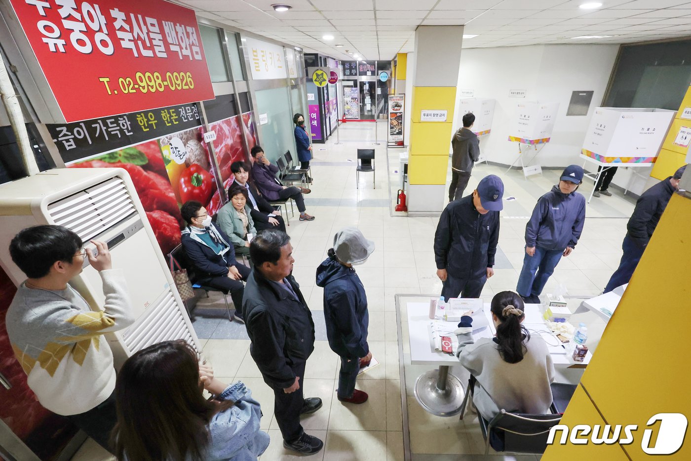 제22대 국회의원선거 투표일인 10일 오전 서울 강북구 수유중앙시장 상가에 마련된 수유3동 제4투표소를 찾은 유권자들이 본인 확인을 받기 위해 줄을 서 기다리고 있다. 2024.4.10/뉴스1 ⓒ News1 민경석 기자