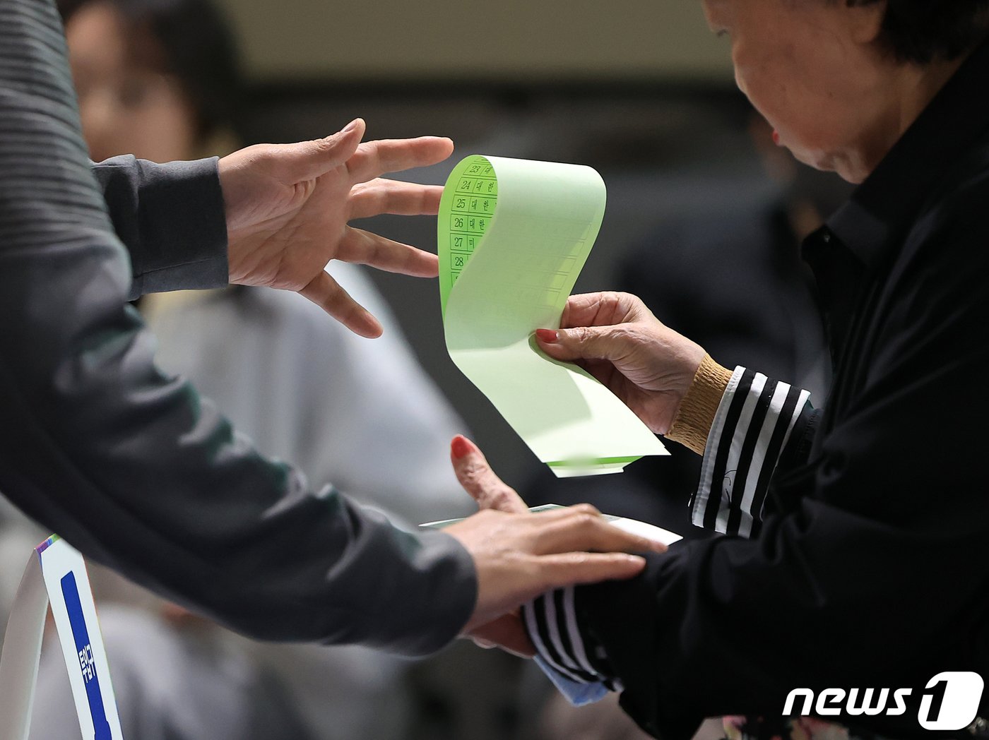 본문 이미지 - 제22대 국회의원 선거일인 10일 오전 서울 서대문구 홍제배드민턴장에 마련된 홍제 제3동 제3투표소를 찾은 유권자가 투표소 관계자에게 투표용지 투입 전 안내를 받고 있다. 2024.4.10/뉴스1 ⓒ News1 김진환 기자