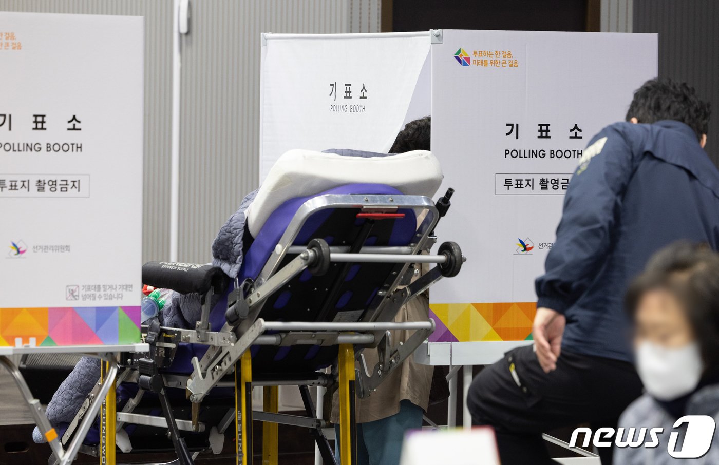 본문 이미지 - 22대 국회의원선거 투표일인 10일 오전 서울 용산구 중부기술교육원에 마련된 한남동 제3투표소에서 한 중증환가 가족의 도움을 받아 투표하고 있다. 2024.4.10/뉴스1 ⓒ News1 이재명 기자