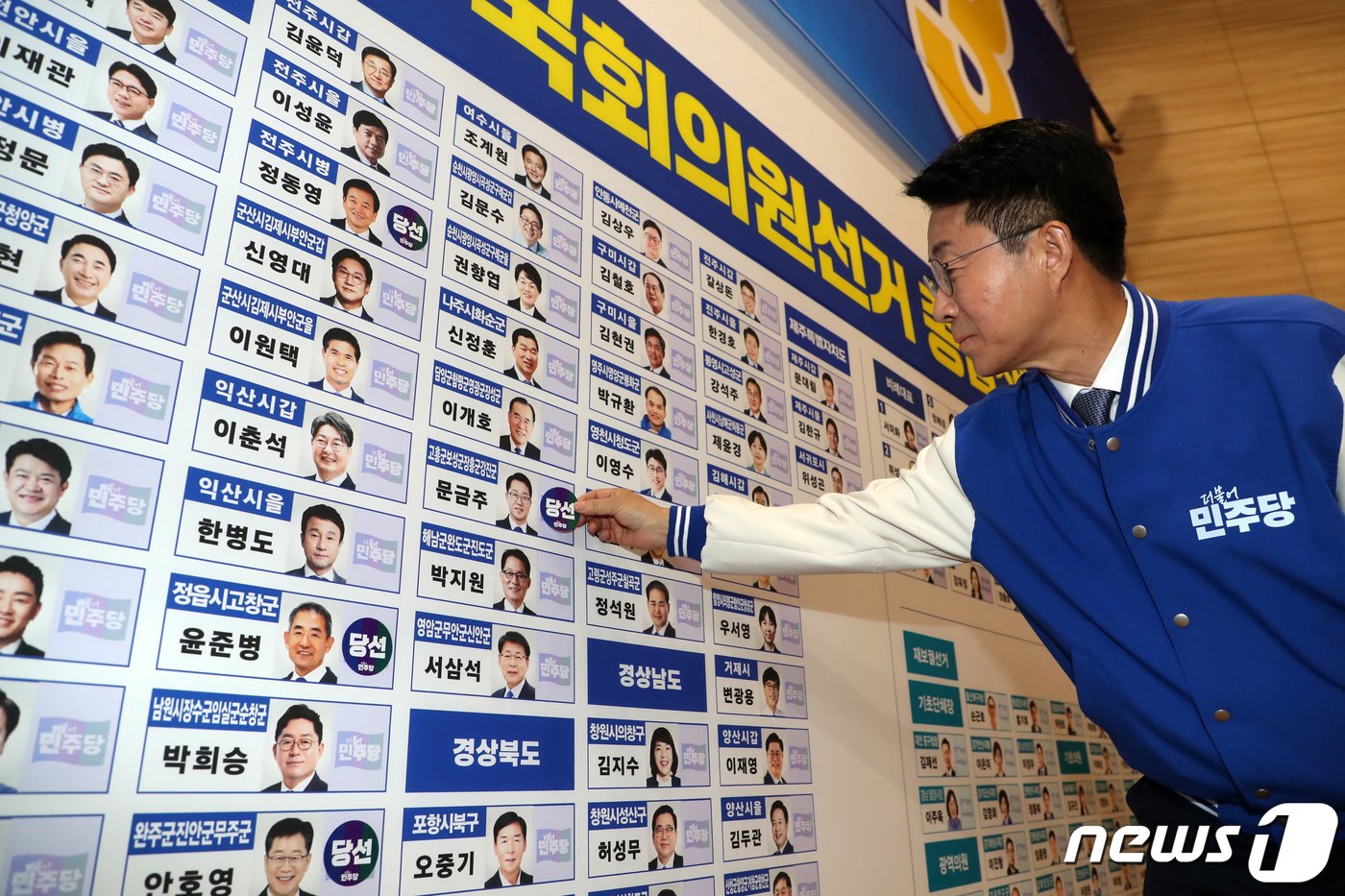 조정식 더불어민주당 사무총장이 10일 국회 의원회관 제22대 국회의원선거 상황실에서 개표초반 일찌감치 당선된 문금주 전남 고흥보성장흥강진 후보 이름표에 당선스티커를 붙이고 있다. &#40;공동취재&#41; 2024.4.10/뉴스1 ⓒ News1 임세영 기자