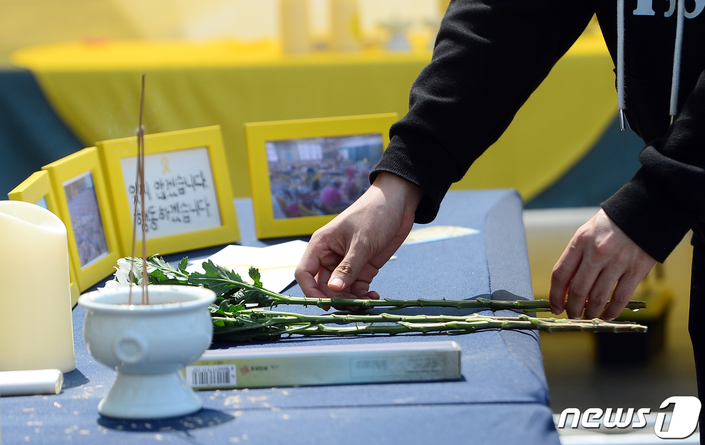 (광주=뉴스1) 이승현 기자 = 4·16 세월호 참사 10주기를 나흘 앞둔 12일 광주 동구 5·18민주광장에 설치된 시민분향소에서 한 시민이 헌화를 하며 희생자를 추모하고 있다. …