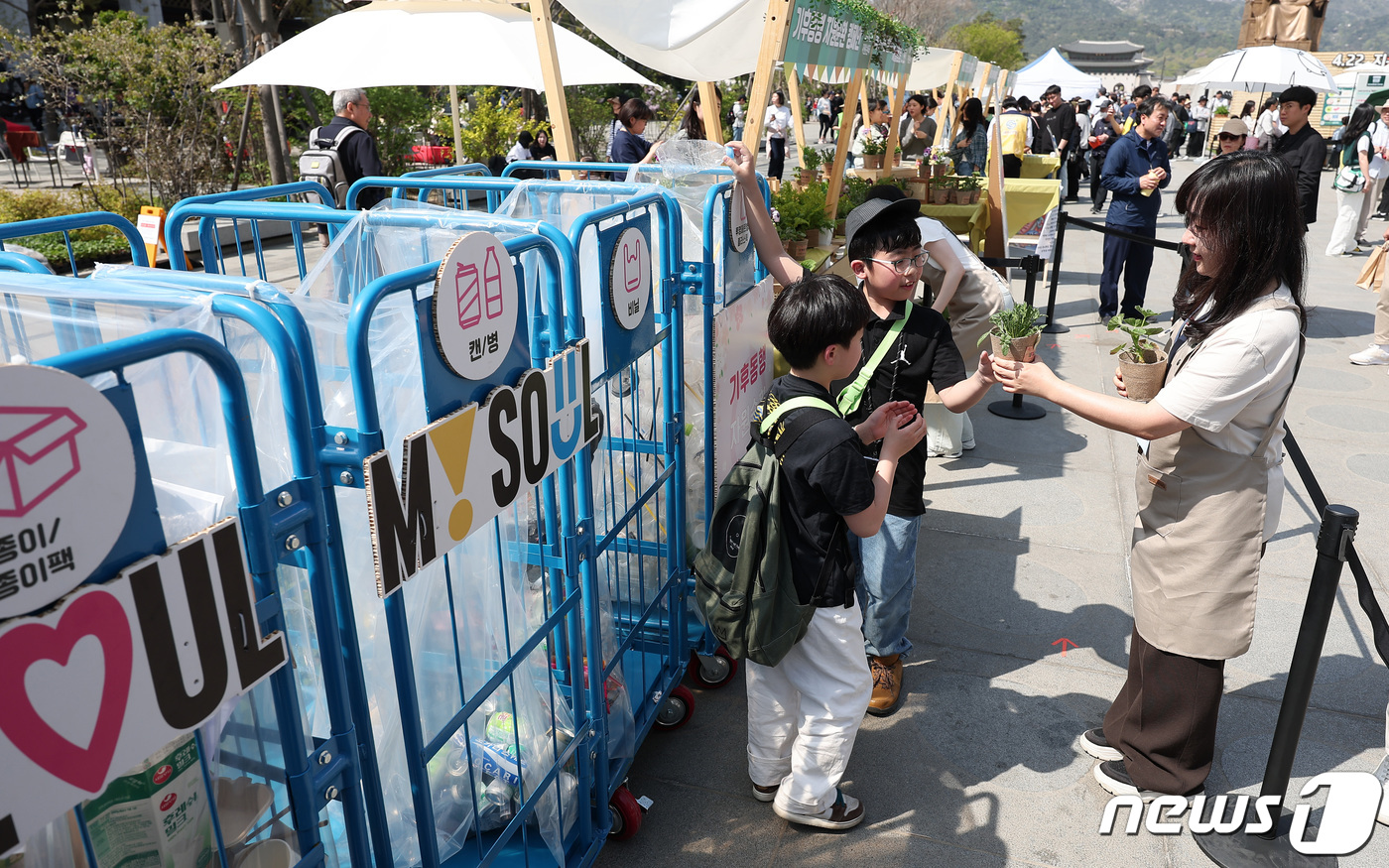(서울=뉴스1) 김성진 기자 = 13일 서울 종로구 광화문광장에서 열린 '2024 지구의 날' 기념행사에서 한 어린이가 분리수거를 한 후 화분을 받고 있다.지구의 날(매년 4월 2 …