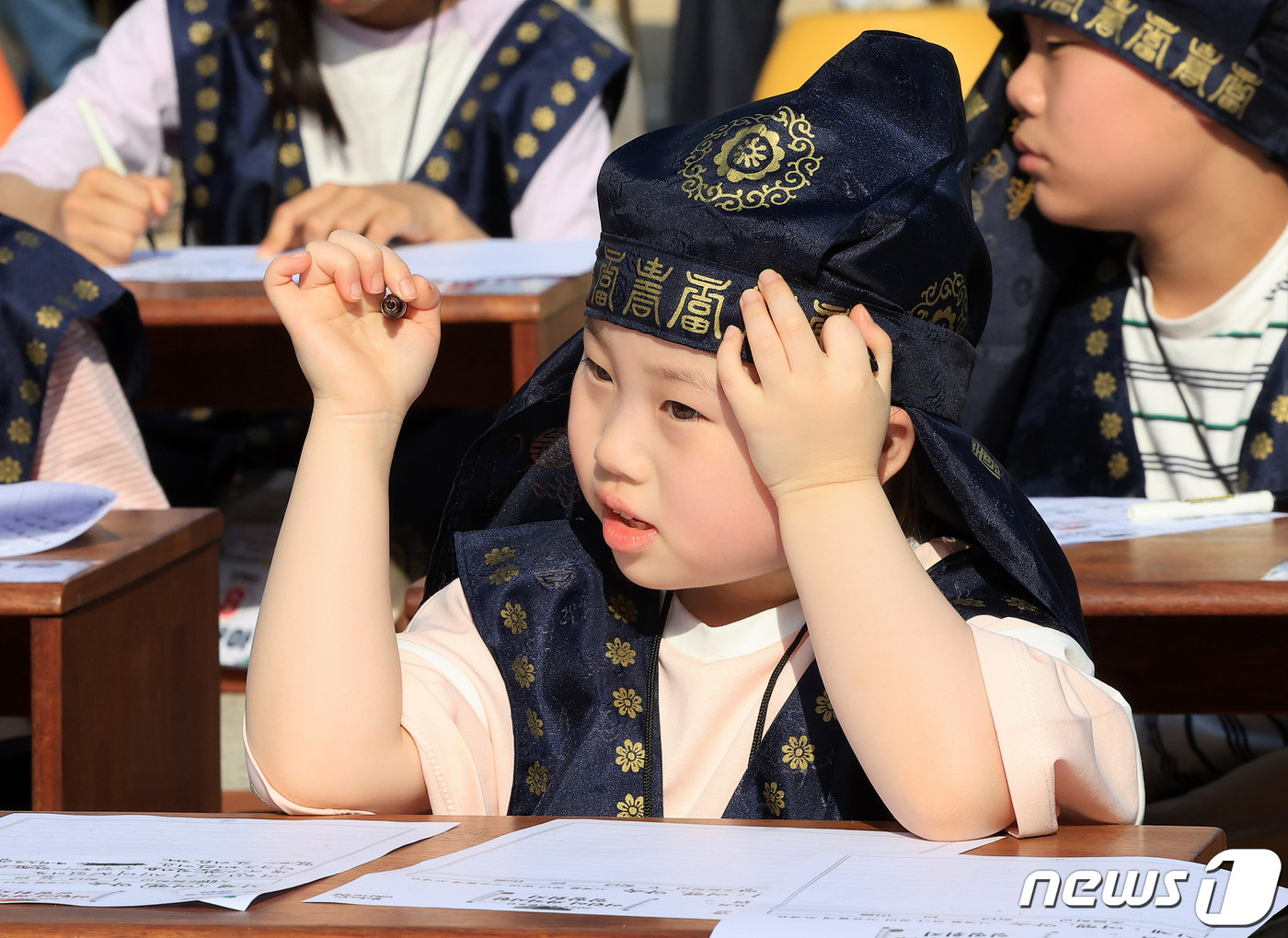 (서울=뉴스1) 김진환 기자 = 13일 오후 서울 강남구 못골한옥어린이도서관에서 열린 ‘2024 어린이 과거시험 일필휘지(一筆揮之)’에서 유생복장을 한 어린이들이 시제인 '여행'과 …