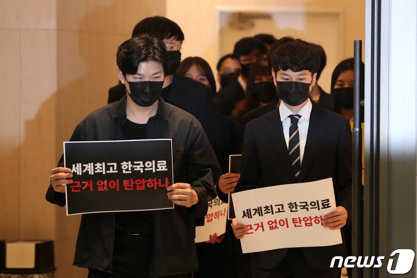 본문 이미지 - 사직 전공의들이 15일 오전 서울 용산구 대한의사협회에서 열린 박민수 보건복지부 제2차관 집단고소 기자회견에 손피켓을 들고 참석하고 있다. 2024.4.15/뉴스1 ⓒ News1 이승배 기자