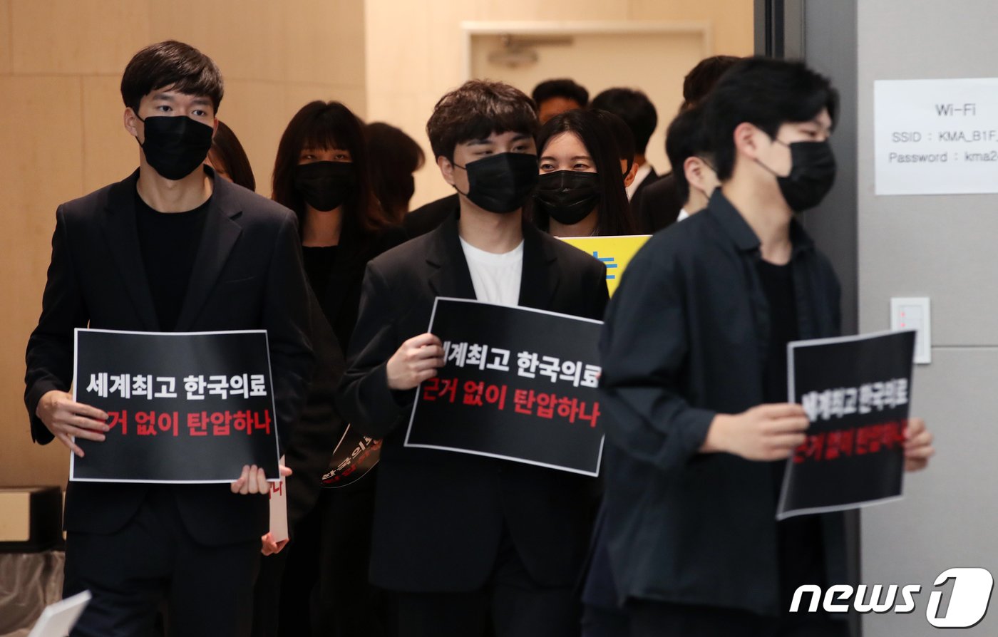 본문 이미지 - 사직 전공의들이 15일 오전 서울 용산구 대한의사협회에서 열린 박민수 보건복지부 제2차관 집단고소 기자회견에 손피켓을 들고 참석하고 있다. 사직 전공의 1,362명은 이날 기자회견을 통해 박민수 보건복지부 제2차관 등을 직권 남용 및 권리 행사 방해 혐의로 고소한다고 밝혔다. 2024.4.15/뉴스1 ⓒ News1 이승배 기자