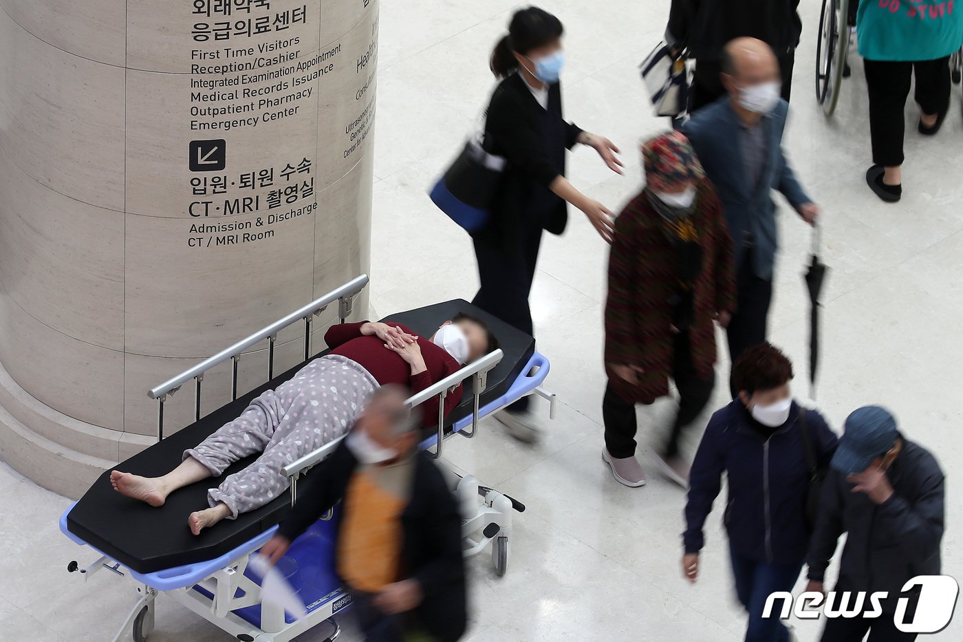 본문 이미지 - 의대 증원을 둘러싼 의정갈등이 장기화하고 있는 가운데 15일 대구의 한 대학병원을 찾은 환자가 이동용 침상에 누워 대기하고 있다. 2024.4.15/뉴스1 ⓒ News1 공정식 기자