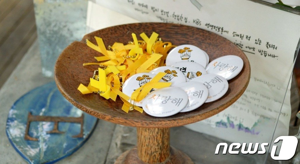 본문 이미지 - 서촌 가게에 비치된 무료 나눔 노란리본과 뱃지 (참여연대 제공)