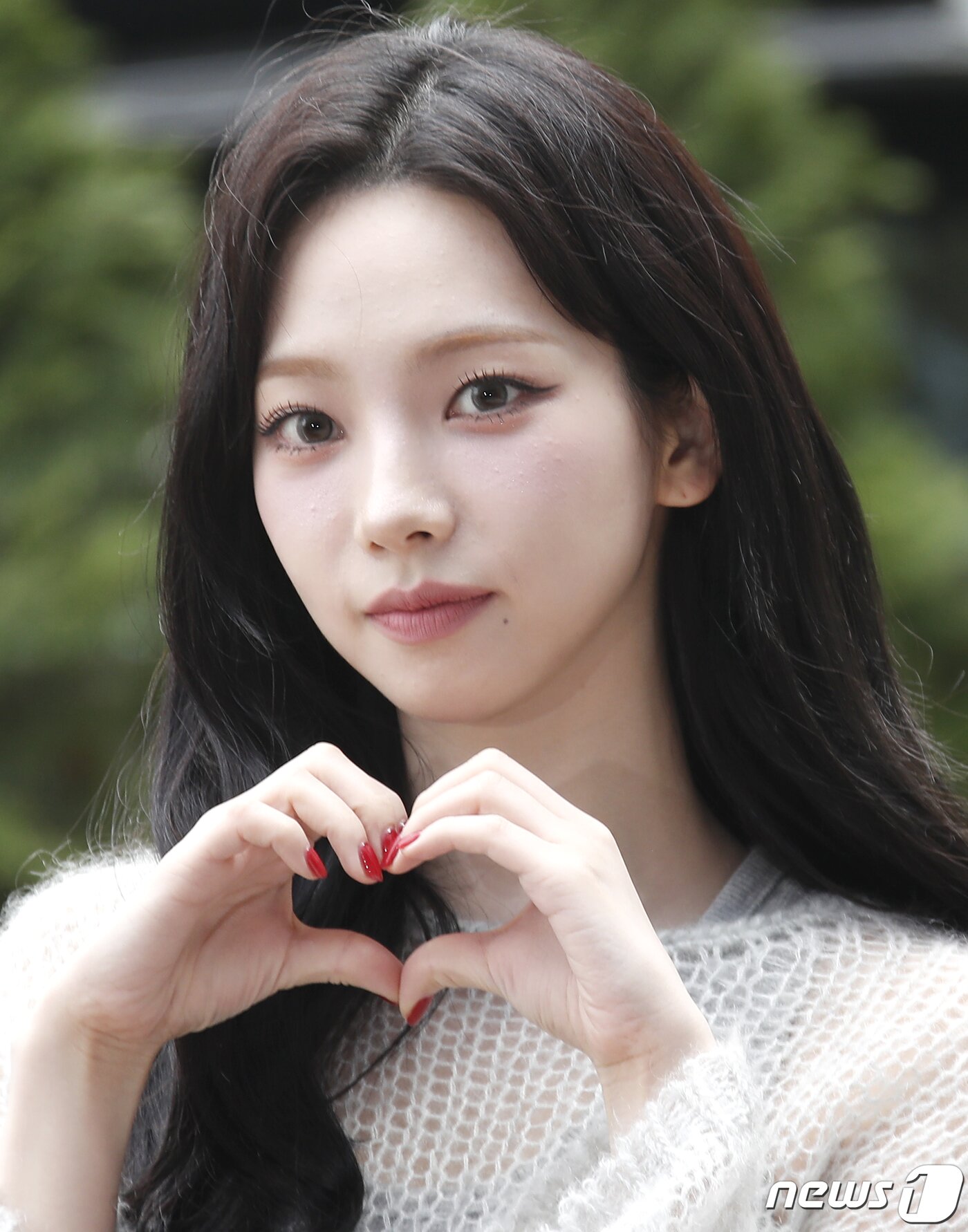 본문 이미지 - 에스파 카리나가 '싱크로유' 녹화를 위해 16일 서울 영등포구 KBS에 도착해 환호하는 팬을 향해 하트를 그리고 있다. ⓒ News1 권현진 기자
