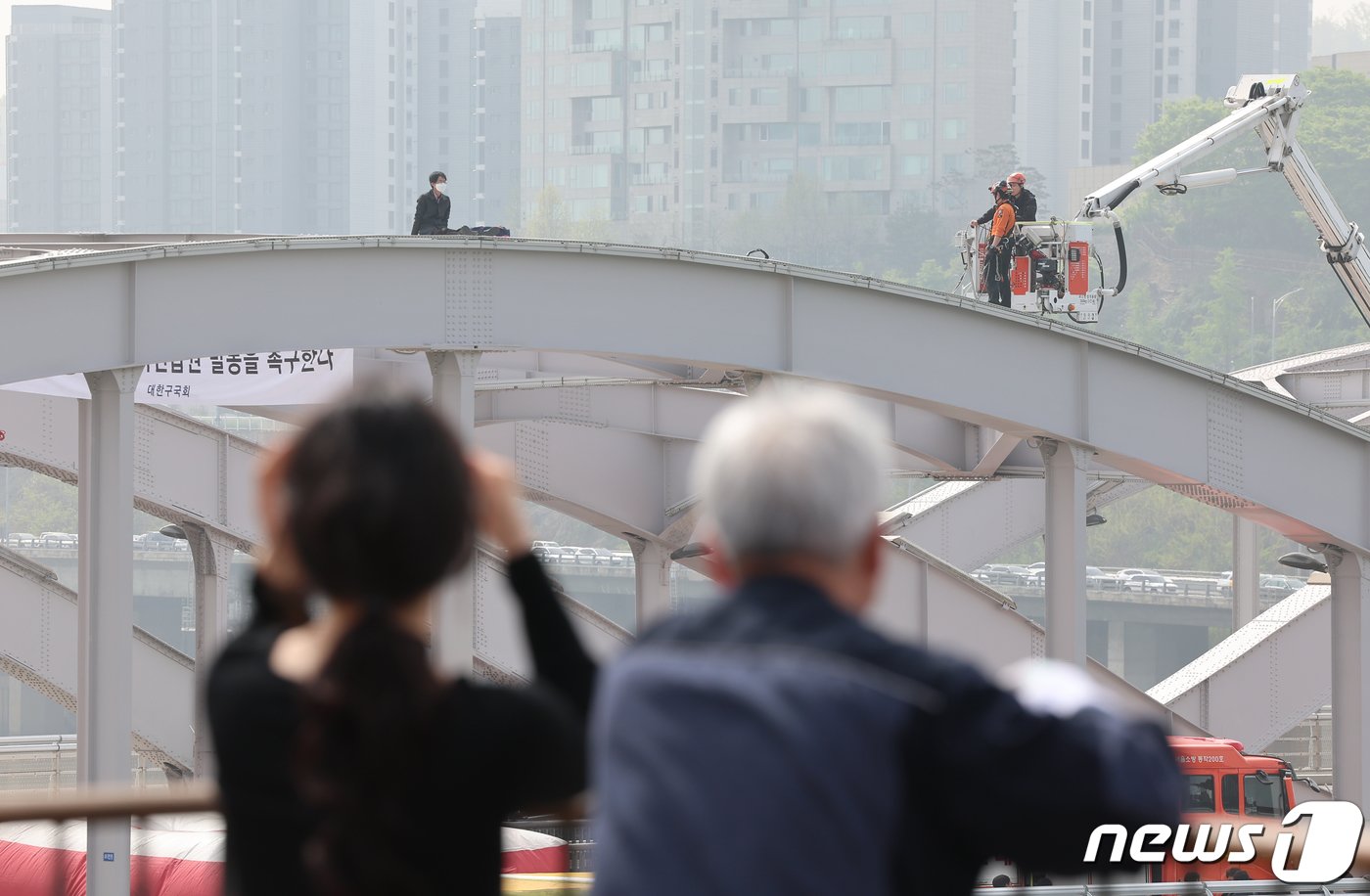 17일 오전 서울 한강대교 노량진 방면에서 신원을 알 수 없는 남성이 교량 위에 올라가 소동을 벌이고 있다. 2024.4.17/뉴스1 ⓒ News1 김도우 기자