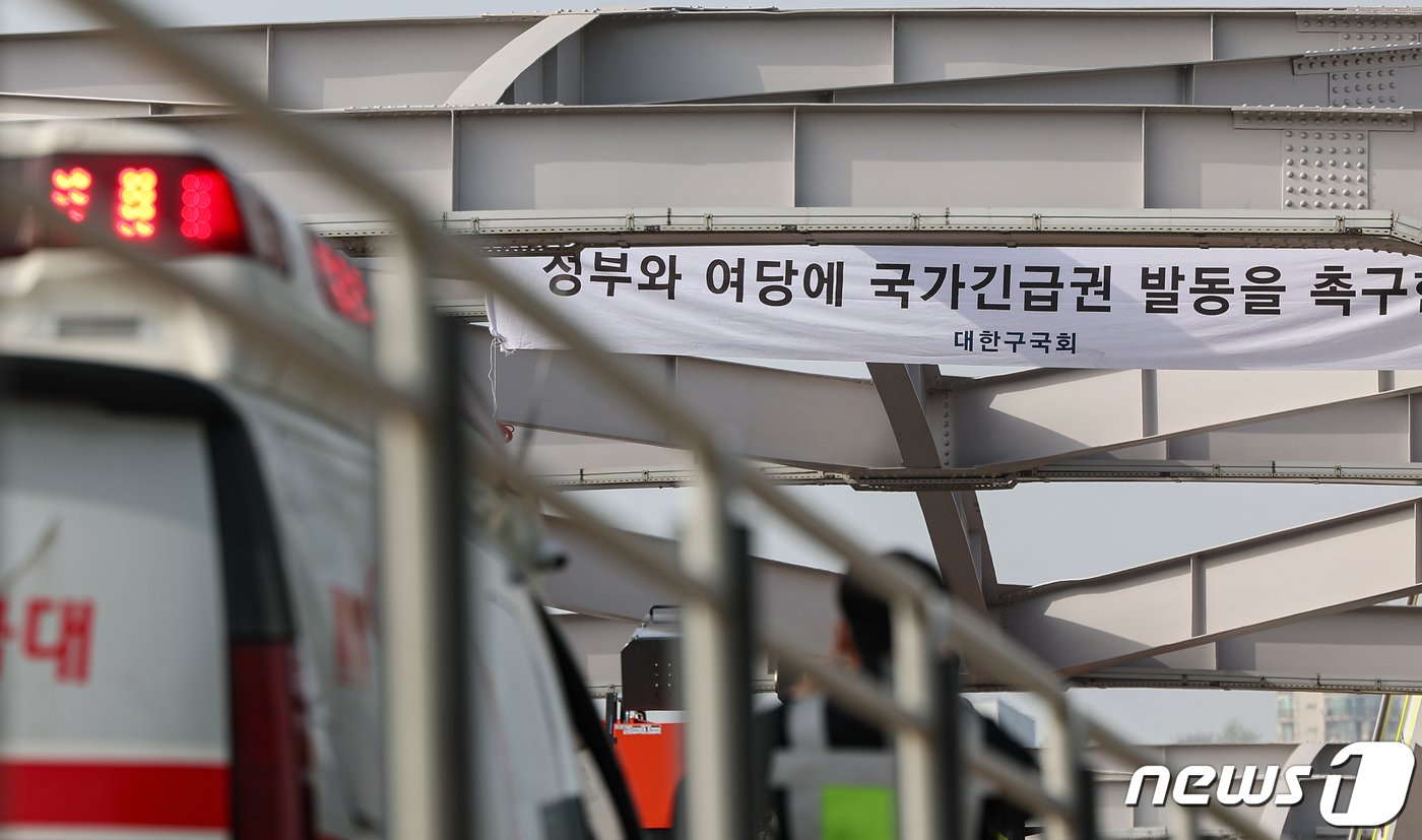 본문 이미지 - 17일 오전 서울 한강대교에 신원을 알 수 없는 남성이 교량 위에 올라가 설치한 현수막이 걸려 있다. 2024.4.17/뉴스1 ⓒ News1 김도우 기자