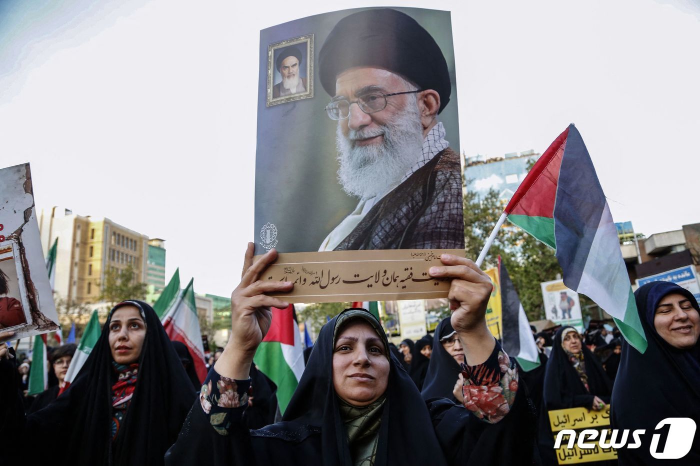 이스라엘이 이란의 공습을 받은 다음 날인 15일&#40;현지시간&#41; 한 이란 여성이 아야톨라 알리 하메네이 이란 최고지도자의 사진을 들고 거리로 나서고 있다. 2024.04.15 ⓒ AFP=뉴스1 ⓒ News1 정지윤 기자