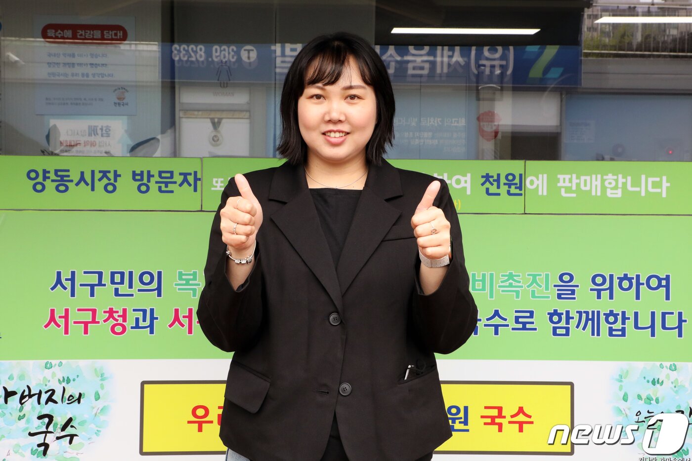 본문 이미지 - 김은성 광주서구시니어클럽 과장이 천원국시 매장 앞에서 기념촬영하고 있다./뉴스1DB ⓒ News1 이수민 기자