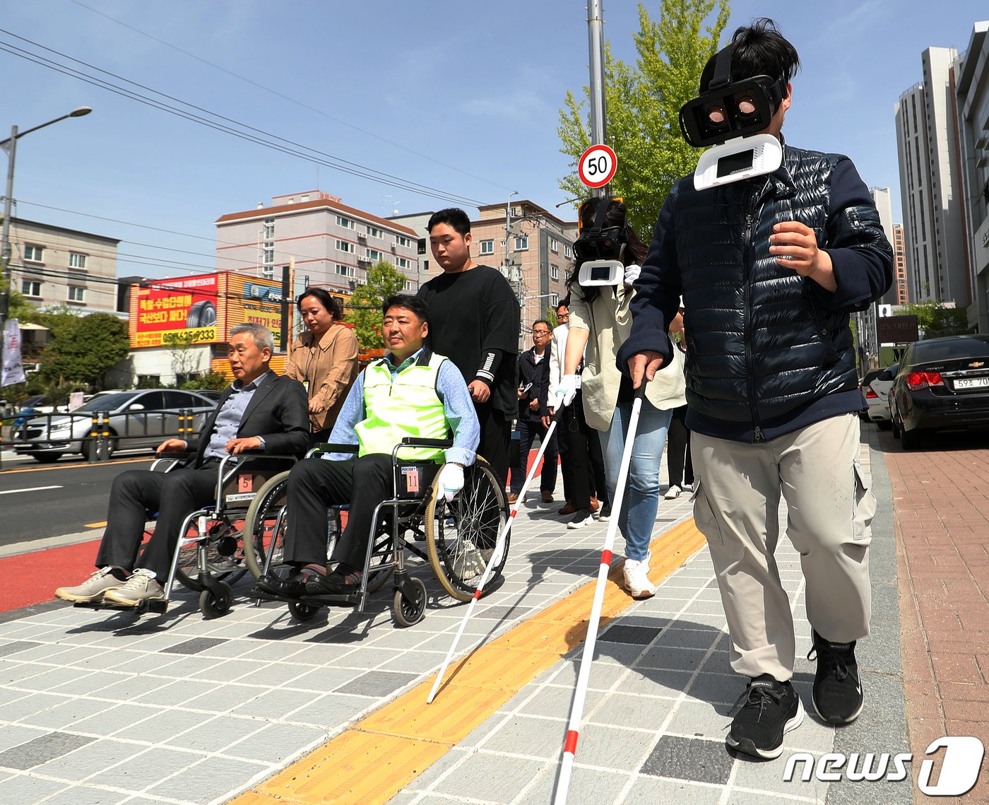 제44회 장애인의 날을 하루 앞둔 지난 4월 19일 오후 부산 남구장애인복지관 인근 보도에서 열린 명사 초청 장애인 보행환경 체험행사에서 오은택 부산 남구청장을 비롯한 참석자들이 수동 휠체어, 저시력장애 체험 고글, 시각장애인용 흰 지팡이를 사용한 채 보행약자 불편 체험을 하고 있다.ⓒ News1 윤일지 기자