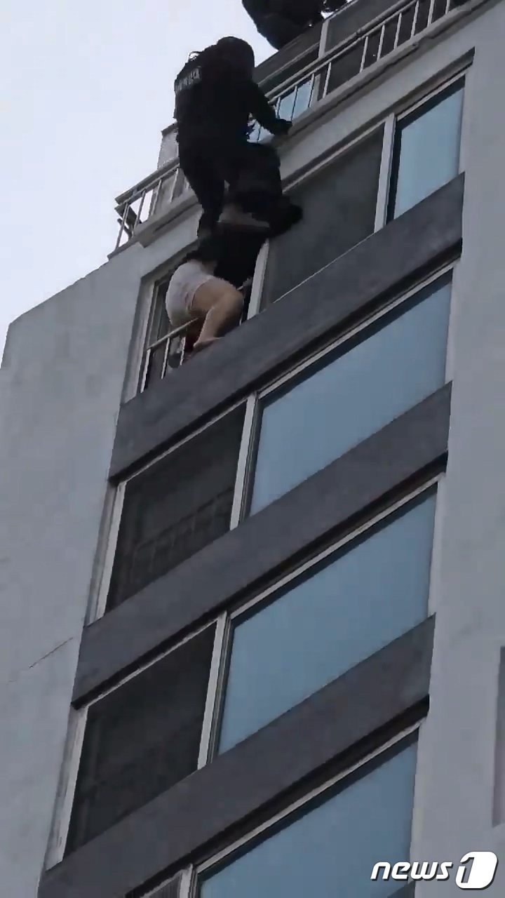 본문 이미지 - 상습절도 혐의 40대 여성이 베란다에서 뛰어 내리려 하자 경찰특공대가 진압하는 모습.(경기남부경찰청 제공)