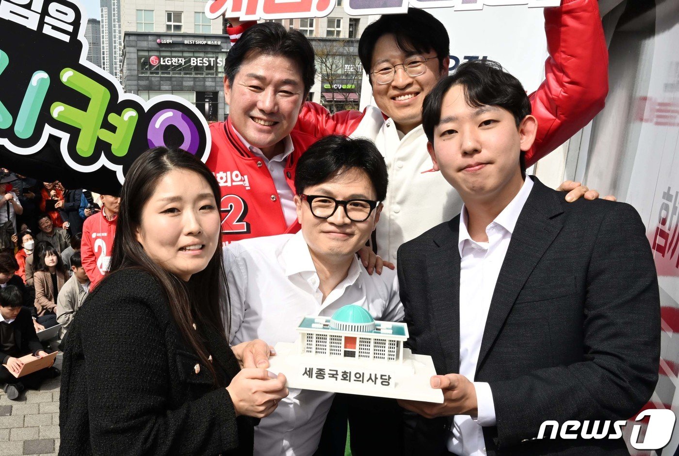 본문 이미지 - 한동훈 국민의힘 총괄 선거대책위원장이 2일 세종시 한누리대로 일대에서 열린 류제화(세종시갑) 후보, 이준배(세종시을) 후보 지원유세에서 세종시 청년들에게 세종국회의사당 모형을 전달한 뒤 기념촬영을 하고 있다. (공동취재) 2024.4.2/뉴스1 ⓒ News1 김기남 기자