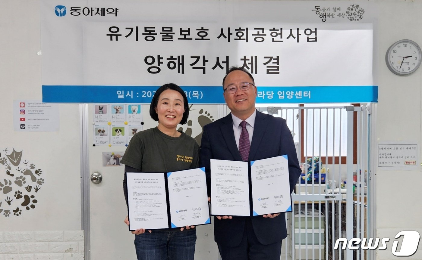 본문 이미지 - 18일 서울 발라당입양센터에서 진행된 유기동물보호 사회공헌사업 업무협약식에서 백상환 동아제약 대표이사 사장(오른쪽)과 최미금 동물과 함께 행복한 세상 대표가 기념 촬영을 하고 있다. ⓒ 뉴스1 최서윤 기자