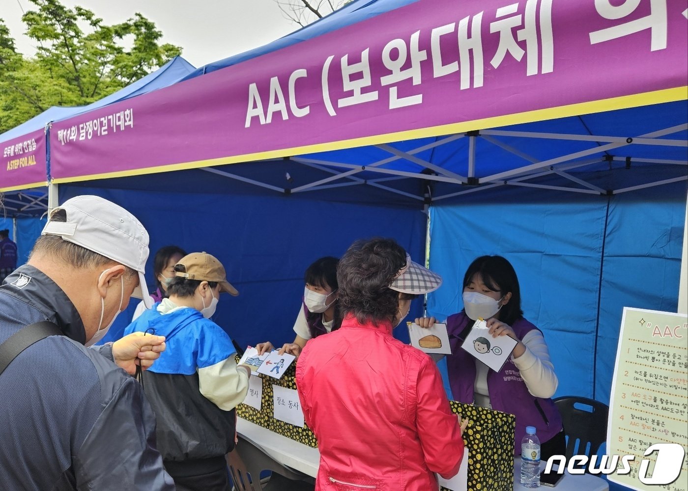 20일 부산 해운대구 APEC 나루공원 일원에서 열린 제11회 담쟁이걷기대회에 마련된 AAC 체험부스에서 시민들이 보완대체 의사소통을 체험하고 있다.2024.4.20/뉴스1 ⓒ News1 조아서 기자