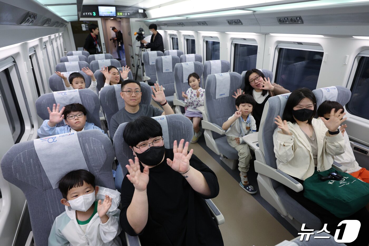 본문 이미지 - 22일 오전 서울 중구 봉래동 서울역에서 열린 &#39;KTX-청룡&#39; 첫 시승 행사에 참여한 국민 시승단이 열차에 탑승해 취재진을 향해 손을 흔들고 있다. 100% 국내기술로 설계·제작된 차세대 동력분산식 고속열차인 &#39;KTX-청룡&#39;의 총 좌석 수는 515석이며, 차량의 설계속도는 352km, 영업속도는 320km로 국내에서 가장 빠른 고속열차다. 대국민 열차 명칭 공모를 통해 접수된 9,192건의 후보안 중 네이밍 개발 및 브랜드 전문가 자문을 거처 최종 선정된 이름인 &#39;KTX-청룡&#39;은 짙은 푸른 색상과 옆면에 쭉 뻗은 황금색 곡선이 청룡을 닮았다. 한편 코레일은 국토교통부와 함께 오는 25일까지 경부선, 호남선 각 2회 각 300명씩&#40;일반 260, 다자녀 40&#41; 모두 네 차례 시승 행사를 진행하고, 다음 달 1일 첫 운행을 시작한다. 2024.4.22/뉴스1 ⓒ News1 박정호 기자