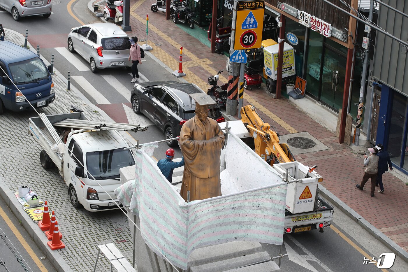 본문 이미지 - 22일 오후 대구 중구 달성공원 앞에서 철거업체 관계자들이 순종 황제 동상을 철거하기 위해 가림막을 설치하고 있다. 2024.4.22/뉴스1 ⓒ News1 공정식 기자