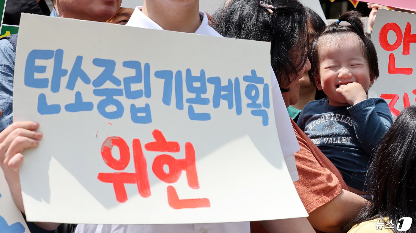 본문 이미지 - 최희우 최연소 소송제기 당사자가 서울 종로구 헌법재판소 앞에서 열린 기후 헌법소원 공개변론 기자회견에서 엄마품에 안겨 웃고 있다. 이날 헌법재판소는 이른바 ‘기후 소송’에 대한 첫 공개 변론을 진행한다. 2024.4.23/뉴스1 ⓒ News1 박지혜 기자