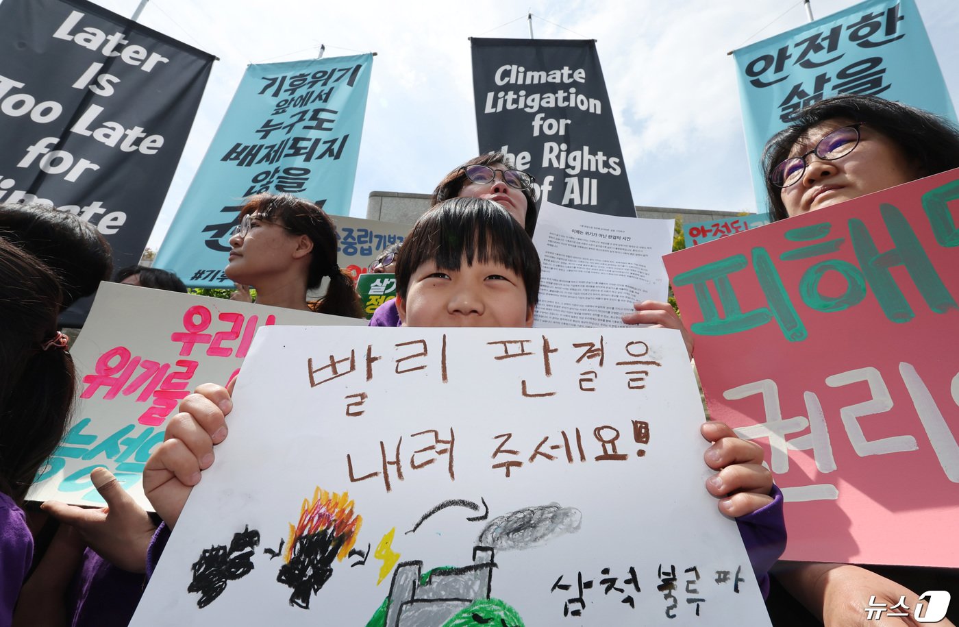 23일 서울 종로구 헌법재판소 앞에서 열린 기후 헌법소원 공개변론 기자회견에 참석한 어린이가 빠른 판결을 촉구하는 손팻말을 들고 있다.. 2024.4.23/뉴스1 ⓒ News1 박지혜 기자