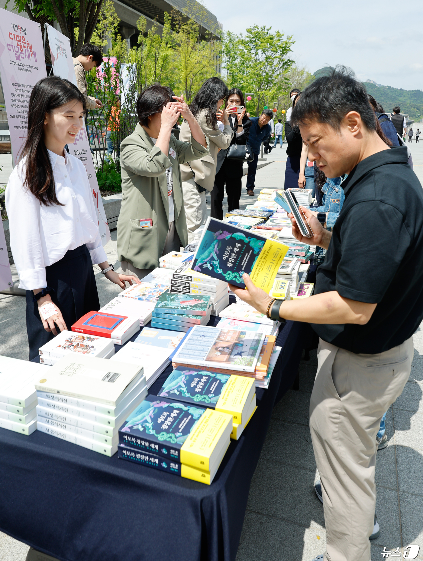 (서울=뉴스1) 안은나 기자 = 세계 책의 날인 23일 서울 종로구 광화문 광장 해치마당에서 문화체육관광부 '더 많은 책, 더 넓은 세계' 행사에 참여한 시민들이 책나눔을 받고 있 …