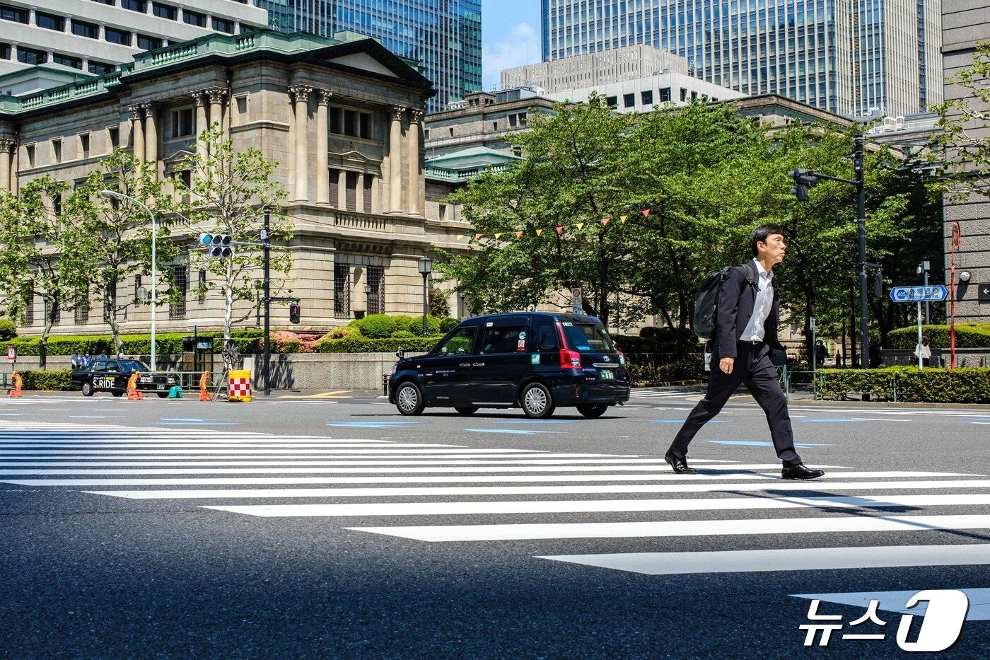 25働いた東京市民が中央銀行である日銀(BoJ)前横断歩道を渡っている. この日円為替がドル当り 155円を突破するによって BoJが介入に出るか注目される. 2024.04.25 c。 AFP=ニュース1 c。 News1 止まりつや者