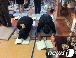 본문 이미지 - 2012년 9월 6일 열린 울산 자매 49재에서 부모가 딸의 극락왕생을 빌고 있다. ⓒ 뉴스1 