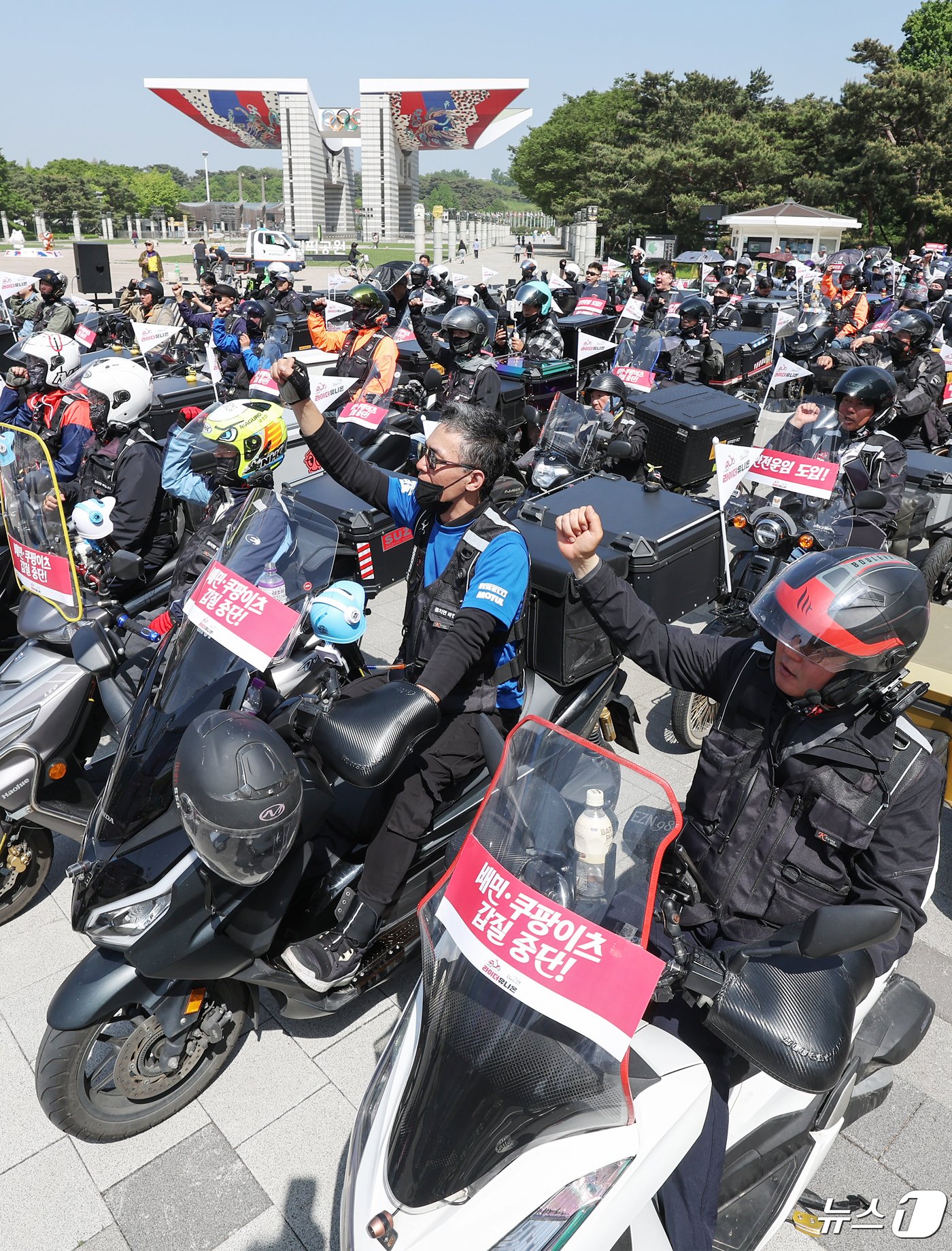 본문 이미지 - 공공운수노조 라이더유니온지부 조합원들이 25일 오후 서울 송파구 올림픽공원 앞에서 &#39;제7회 라이더 대행진&#39; 출발을 앞두고 안전운임제도 도입과 기본 배달료 인상을 촉구하며 구호를 외치고 있다. 2024.4.25/뉴스1 ⓒ News1 민경석 기자