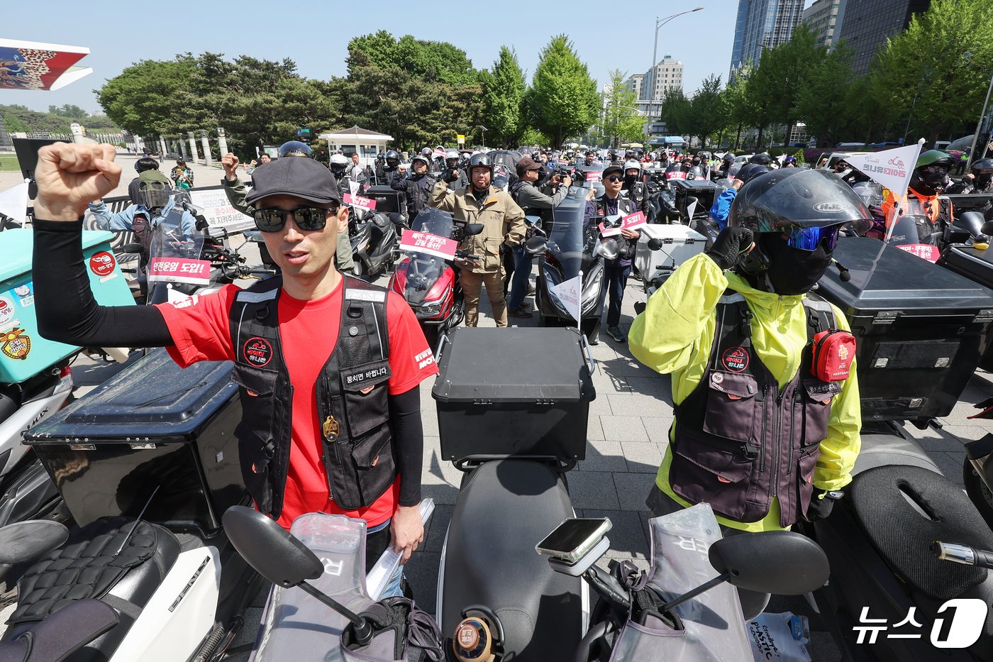 본문 이미지 - 공공운수노조 라이더유니온지부 조합원들이 25일 오후 서울 송파구 올림픽공원 앞에서 &#39;제7회 라이더 대행진&#39; 출발을 앞두고 안전운임제도 도입과 기본 배달료 인상을 촉구하며 구호를 외치고 있다. 2024.4.25/뉴스1 ⓒ News1 민경석 기자