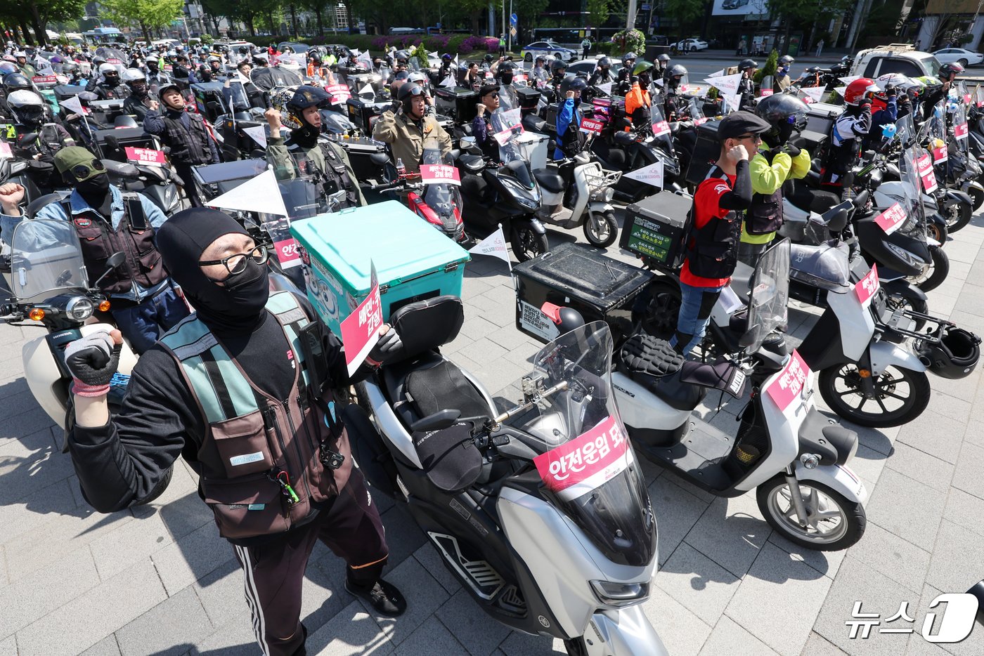 본문 이미지 - 공공운수노조 라이더유니온지부 조합원들이 25일 오후 서울 송파구 올림픽공원 앞에서 &#39;제7회 라이더 대행진&#39; 출발을 앞두고 안전운임제도 도입과 기본 배달료 인상을 촉구하며 구호를 외치고 있다. 2024.4.25/뉴스1 ⓒ News1 민경석 기자