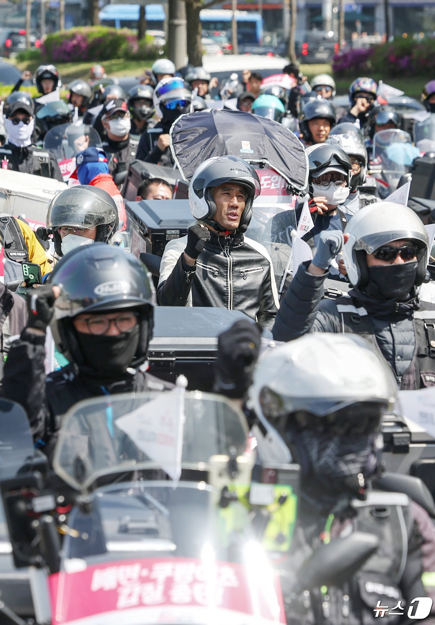 본문 이미지 - 공공운수노조 라이더유니온지부 조합원들이 25일 오후 서울 송파구 올림픽공원 앞에서 &#39;제7회 라이더 대행진&#39; 출발을 앞두고 안전운임제도 도입과 기본 배달료 인상을 촉구하며 구호를 외치고 있다. 2024.4.25/뉴스1 ⓒ News1 민경석 기자