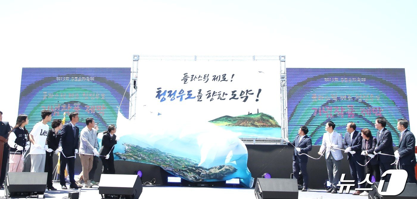 본문 이미지 - 지난 4월27일 제주시 우도에서 열린 '제13회 우도소라축제' 개막에 앞서 '플라스틱 제로 청정 우도 비전' 선포식에서 주민 대표와 주요 내빈들이 '청정우도 캘리그라피' 작품을 공개하고 있다. 2024.2.27/뉴스1 ⓒ News1 강승남 기자