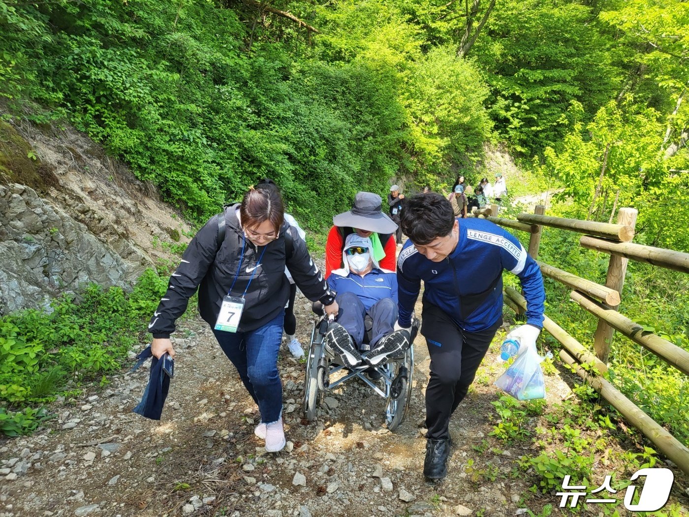 정읍시산악구조대와 정읍시지체장애인협회가 함께한 &#39;아름다운 산행&#39; 봉사단체 회원들이 장애인의 휠체어를 끌고 언덕길을 오르고 있다.&#40;협회 제공&#41;2024.4.28/뉴스1  