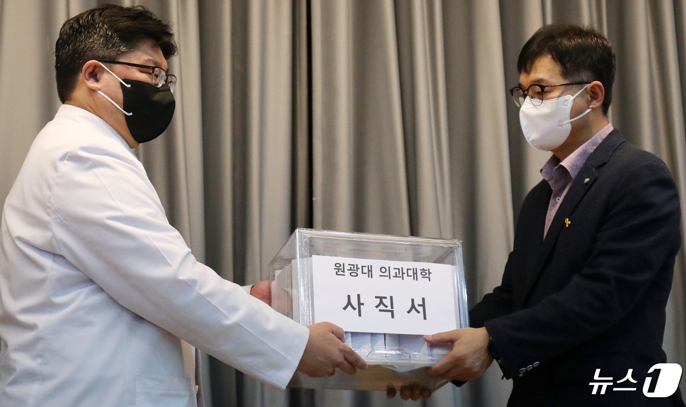 본문 이미지 - 29일 전북자치도 익산시 원광대병원 대강당에서 원광대병원 비상대책위원회 위원장(왼쪽)이 의대 학장에게 사직서를 전달하고 있다. 2024.4.29/뉴스1 ⓒ News1 유경석 기자