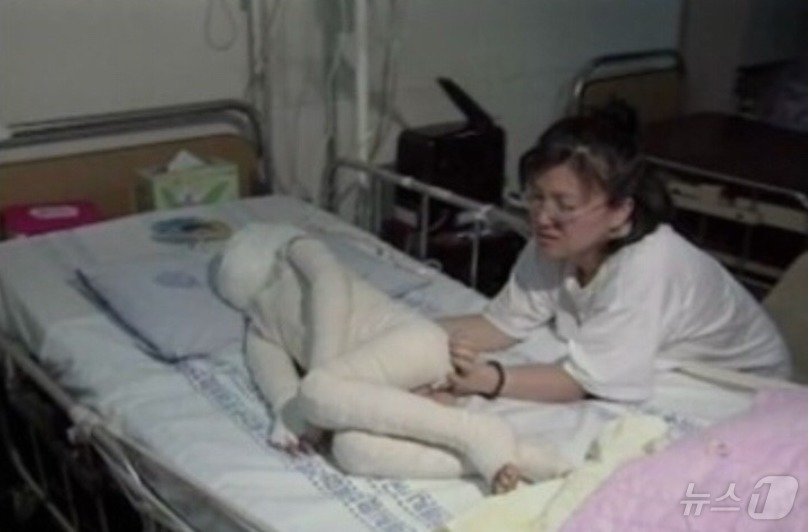  김태완 군 어머니가 전신화상을 당해 누워 있는 아들을 돌보고 있는 모습. &#40;SBS 갈무리&#41; ⓒ 뉴스1 