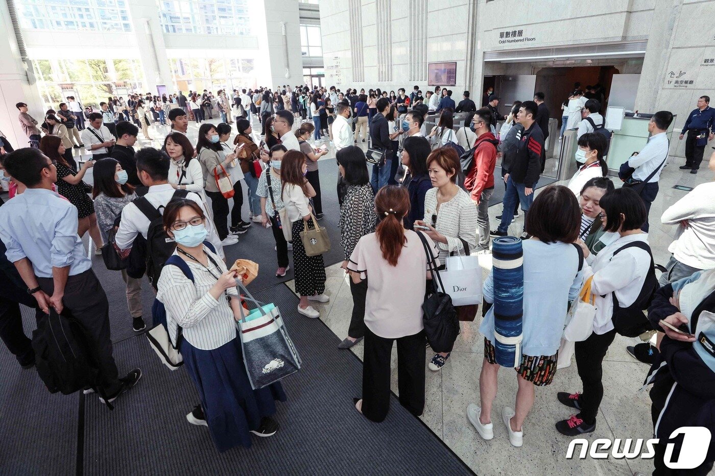 본문 이미지 - 대만을 뒤흔든 강진에 놀란 시민들이 타이베이 101 빌딩 로비에 모여 놀란 가슴을 달래고 있다. ⓒ AFP=뉴스1