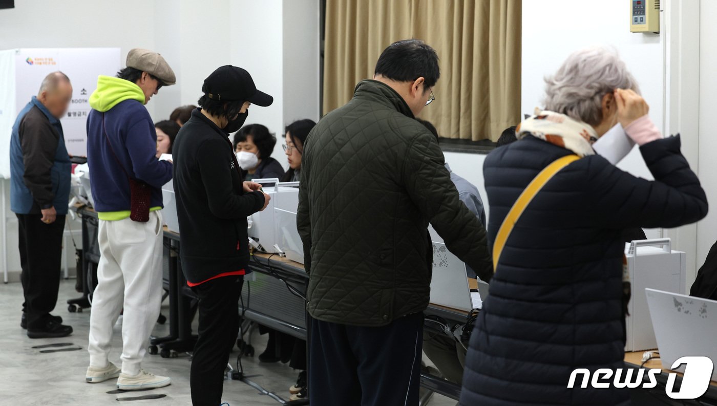 본문 이미지 - 제22대 총선 사전투표 첫날인 5일 서울 영등포구 문래동주민센터에 마련된 사전투표소에서 유권자들이 투표를 하기 위해 본인 확인을 하고 있다. 2024.4.5/뉴스1 ⓒ News1 신웅수 기자