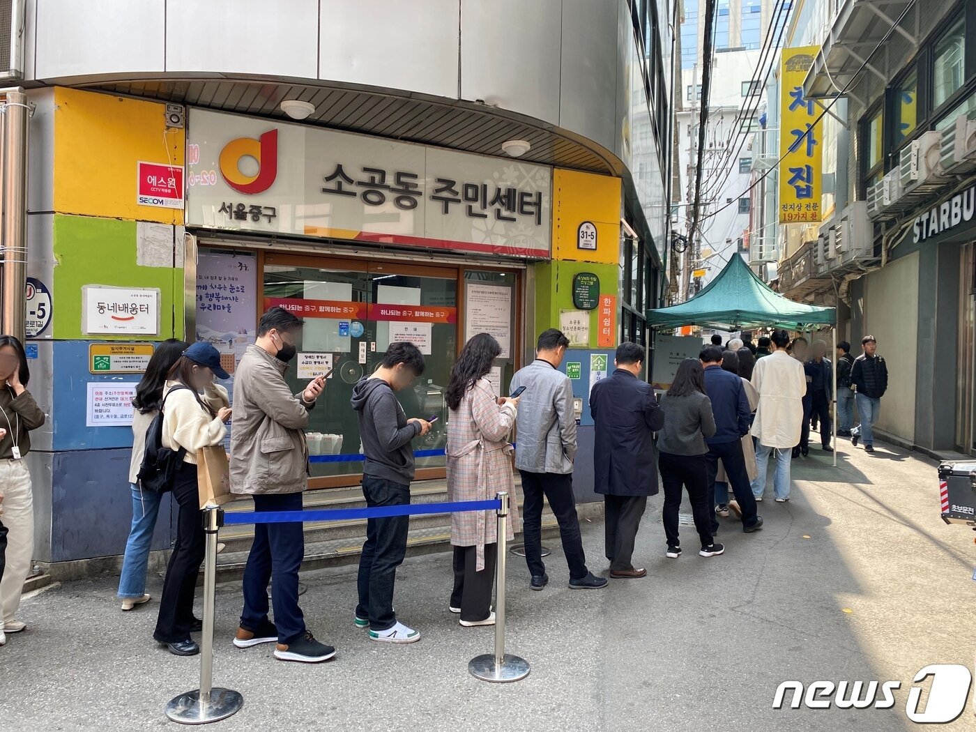 본문 이미지 - 사전투표 첫날인 5일 서울 중구 소공동주민센터 앞에 투표하러 온 직장인들로 줄이 늘어서 있다. / 뉴스1 이기범 기자 