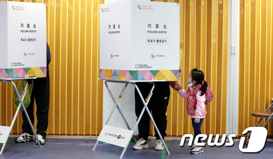 제22대 국회의원선거 사전투표일 첫날인 5일 서울의 한 사전투표소에서 어린이가 투표하는 엄마를 지켜보고 있다. 2024.4.5/뉴스1 © News1 박지혜 기자
