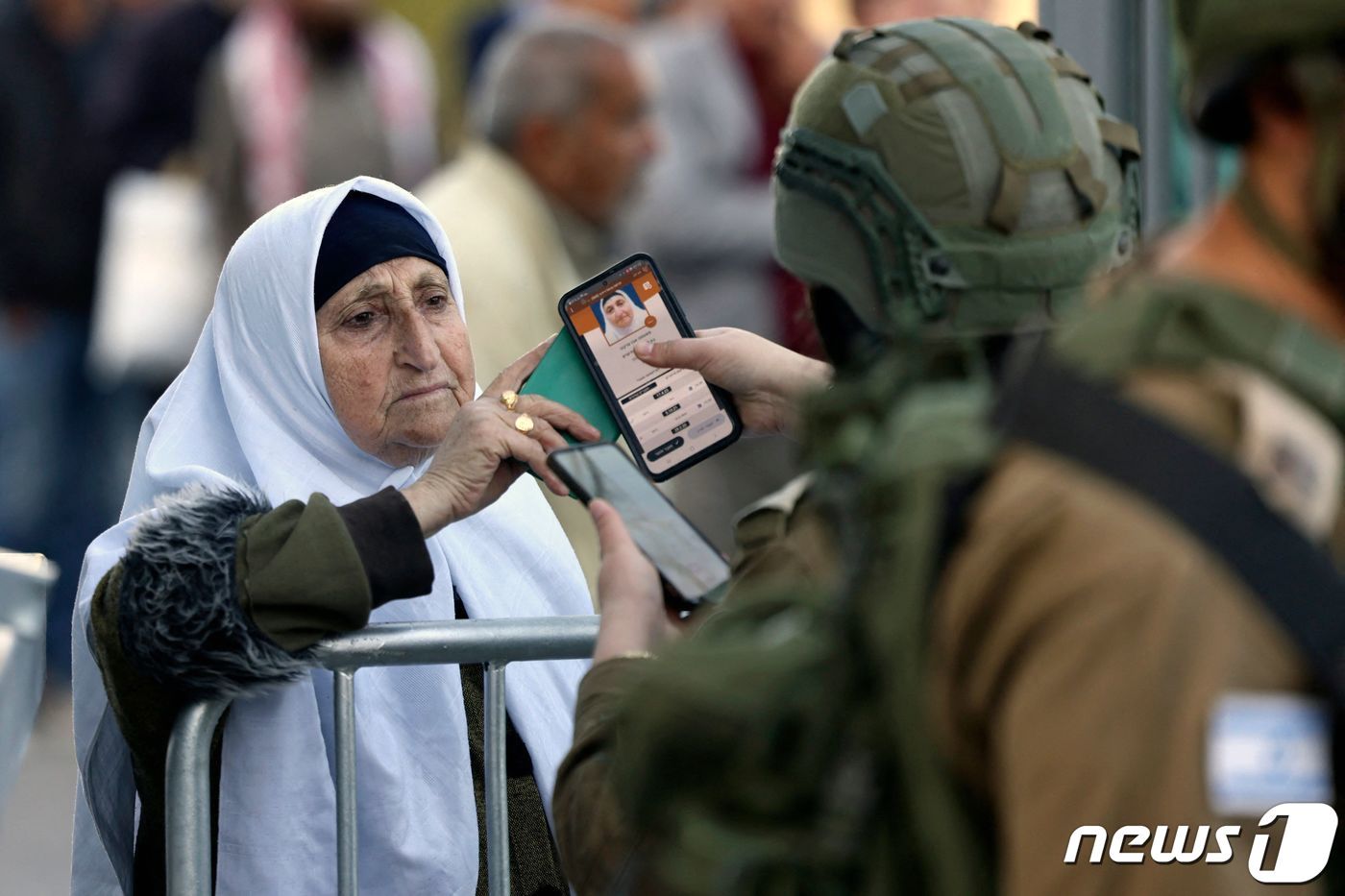 본문 이미지 - 팔레스타인 여인이 5일 라마단 금요기도를 올리려 예루살렘의 알아크사 사원으로 가기위해 베들레헴 이스라엘 검문소에서 신분증을 내보이고있다. 예수가 태어난 베들레헴은 팔레스타인 자치령에 속한다. 2024.04.05 ⓒ AFP=뉴스1 ⓒ News1 김성식기자