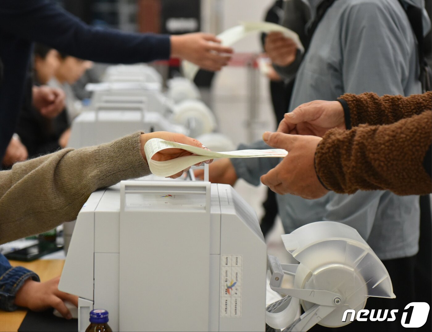 본문 이미지 - 22대 국회의원 선거 사전 투표 둘째날인 6일 오전 광주 북구 용봉동 사전투표소에서 한 유권자가 투표용지를 건네받고 있다. 2024.4.6/뉴스1 ⓒ News1 김동수 기자