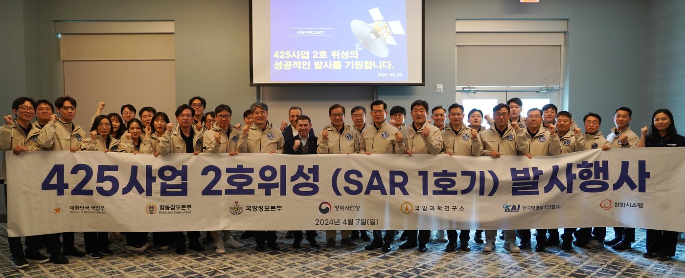 본문 이미지 - KAI 강구영 사장(가운데)이 석종건 방사청장(오른쪽) 및 발사관리단과 함께 SAR 위성 발사 행사기념 현수막을 들고 기념촬영하고 있다(KAI 제공). ⓒ 뉴스1