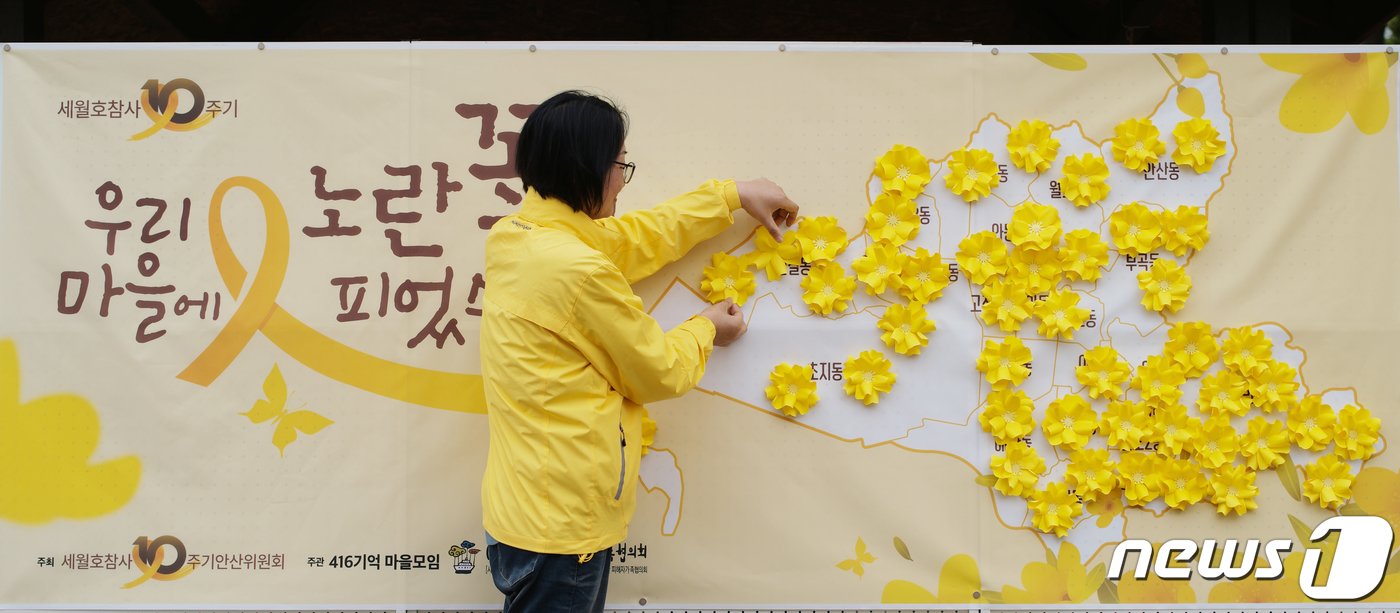 본문 이미지 - 8일 오후 경기 안산시 단원구 단원고등학교 앞에서 열린 &#39;4.16세월호 참사 10주기 기억선포식&#39;에서 유가족이 노란 꽃 전달식 퍼포먼스를 하고 있다. 2024.4.8/뉴스1 ⓒ News1 김영운 기자