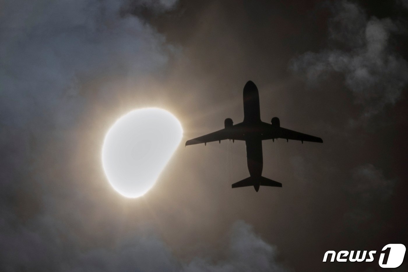 본문 이미지 - 뉴욕주 상공에서 한 비행기가 일식이 진행되는 동안 비행을 하고 있다. ⓒ 로이터=뉴스1 박형기 기자 