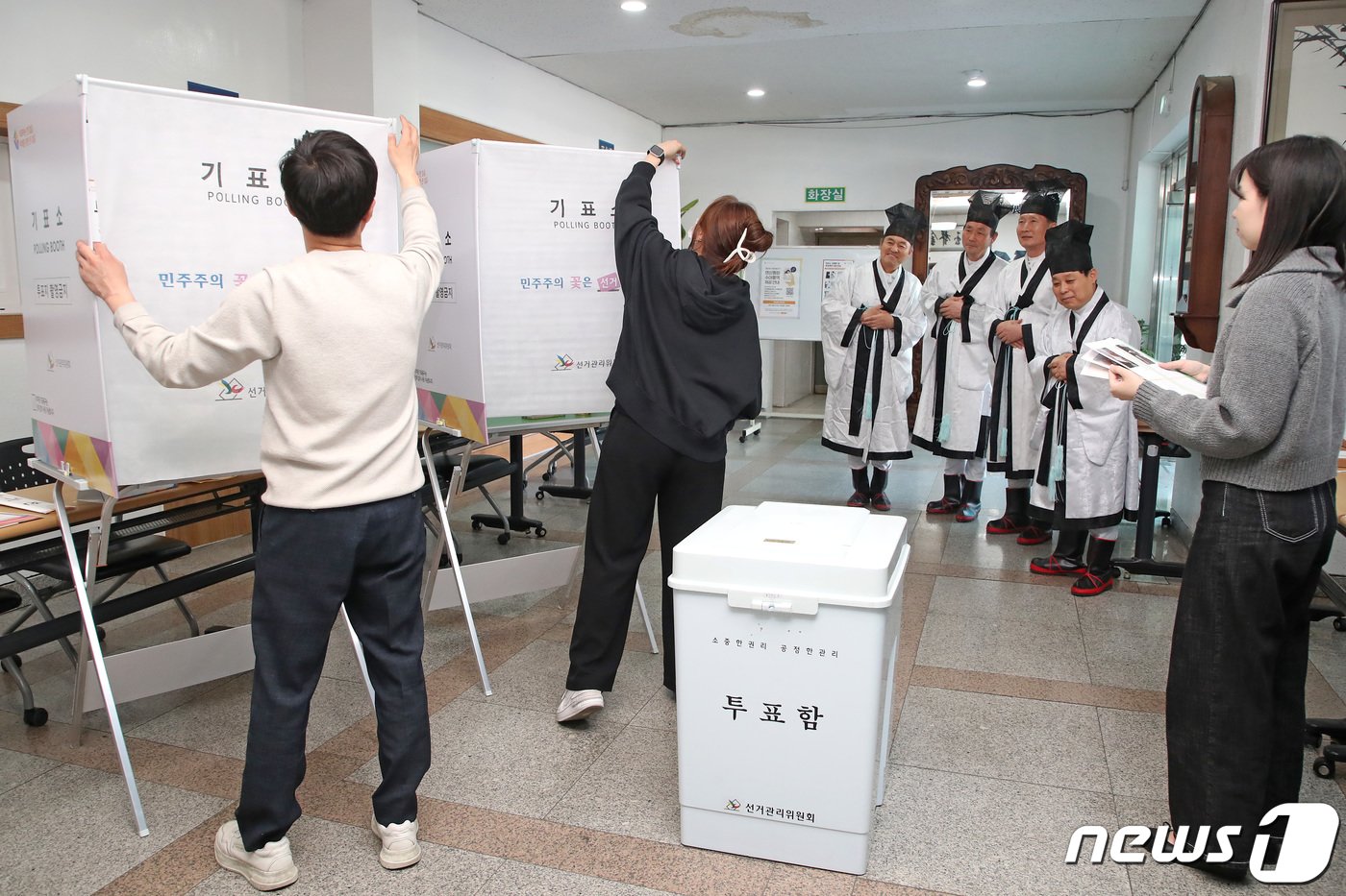본문 이미지 - 제22대 국회의원선거를 하루 앞둔 9일 오후 대구 중구 남산동 대구향교 소강당에서 중구청 관계자들의 투표소 설치 작업을 향교 유림이 신기한 듯 지켜보고 있다. 설치가 완료되면 투표소 출입은 통제되고 투표 개시 전 선거사무원들의 이상 유무 점검 후 투표가 시작된다. 2024.4.9/뉴스1 ⓒ News1 공정식 기자