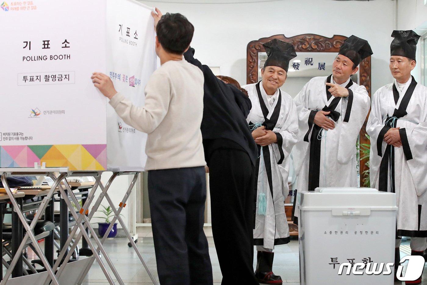 본문 이미지 - 제22대 국회의원선거를 하루 앞둔 9일 오후 대구 중구 남산동 대구향교 소강당에서 중구청 관계자들의 투표소 설치 작업을 향교 유림이 신기한 듯 지켜보고 있다. 설치가 완료되면 투표소 출입은 통제되고 투표 개시 전 선거사무원들의 이상 유무 점검 후 투표가 시작된다. 2024.4.9/뉴스1 ⓒ News1 공정식 기자