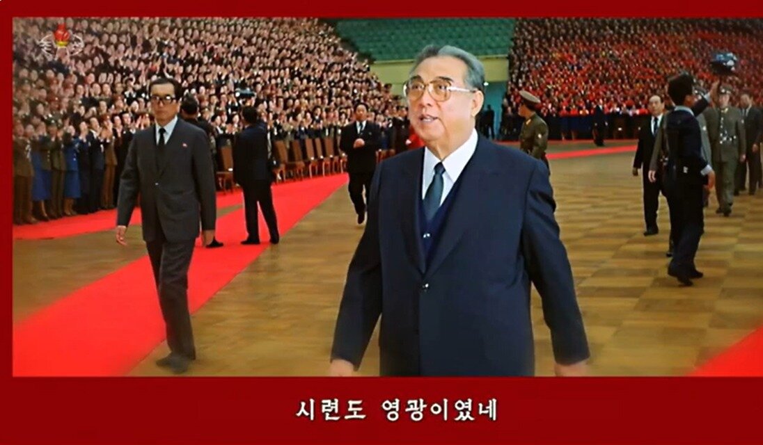 본문 이미지 -  조선중앙TV가  &#39;인생의 영광&#39; 노래 영상을 김기남 전 선전비서가 김일성, 김정일, 김정은 3대에 걸쳐 최고지도자들과 함께 하는 모습으로 편집해 방영했다. &#40;조선중앙TV 갈무리&#41;