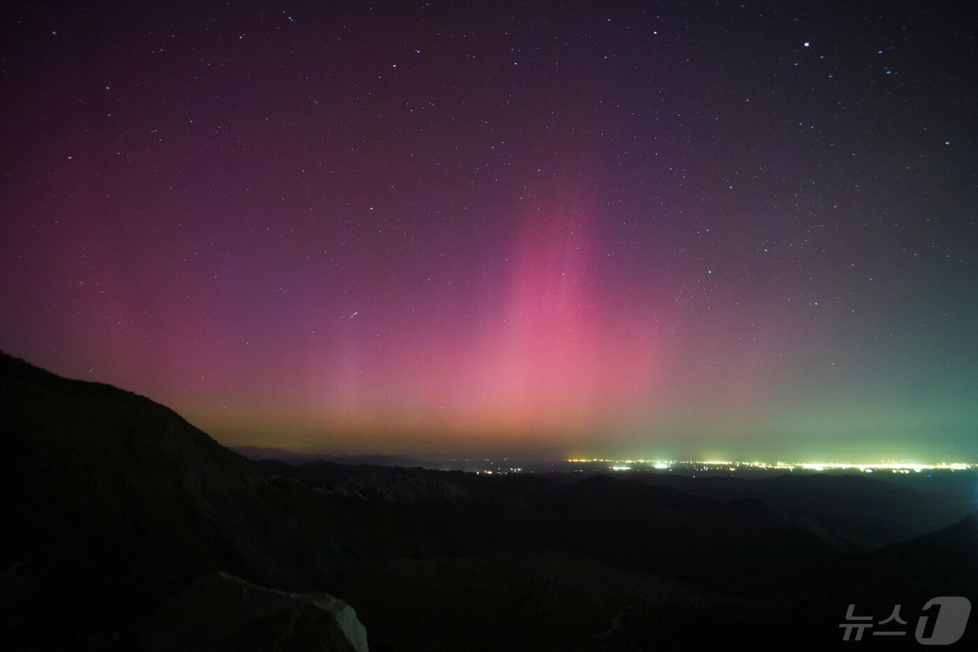 본문 이미지 - 멕시코 테카테에서 바라본 멕시코 멕시칼리와 미국 칼렉시코 국경 도시 상공에서 태양 폭풍으로 인한 오로라 보레알리스의 불빛이 보이고 있다. 2024.5.11 ⓒ 로이터=뉴스1 ⓒ News1 신기림 기자